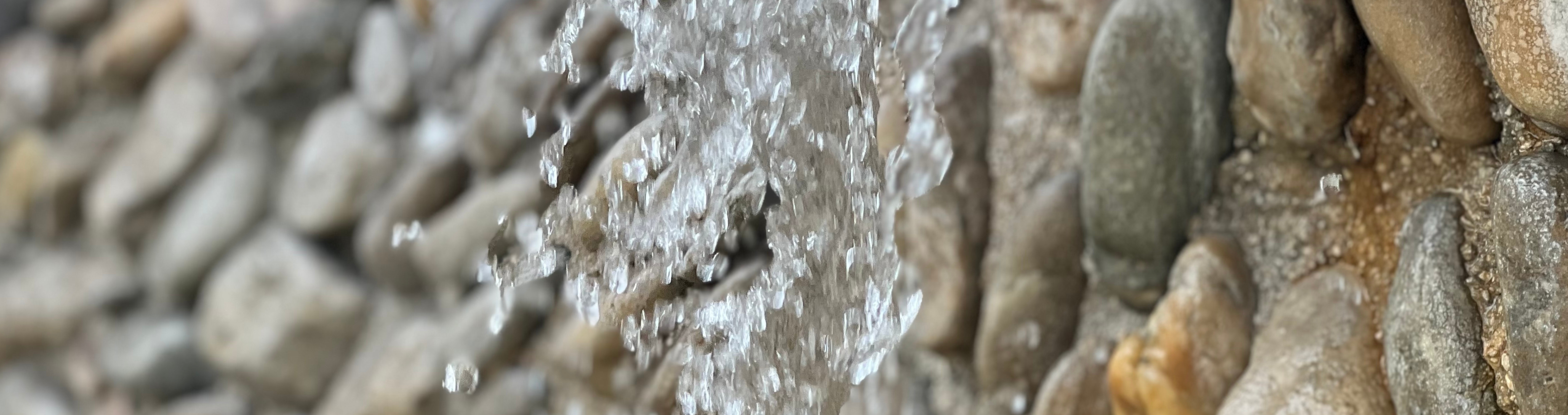 Wasser eines Brunnens mit Kieseln